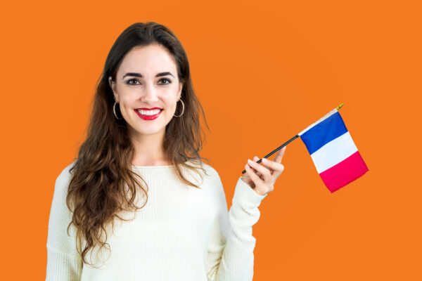 Women on an orange background holding a fench flag