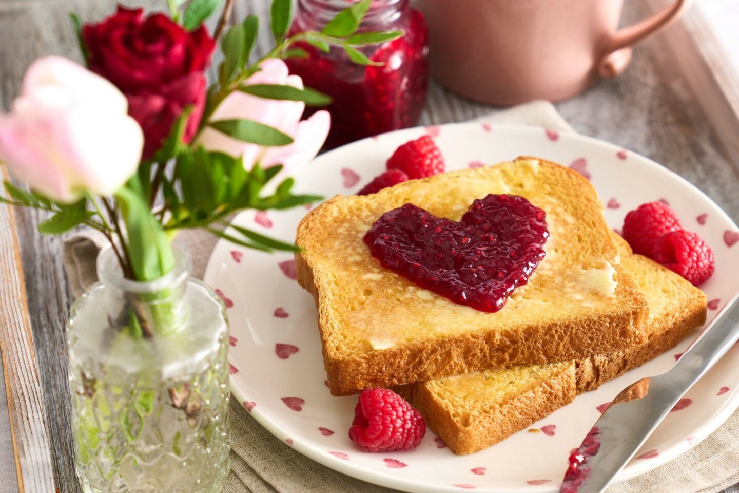 Valentine's Day Breakfast Brioche Loaf Toast With A Jelly Jam Heart And Butter Spread On A Plate With Flowers and Tea